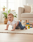 Ein Baby krabbelt über einen weissen Teppich