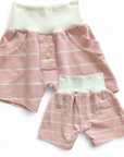 Bunte, kurze Kinderhose aus upgecycelten Stoffen hier aus einem Poloshirt mit elastischem Bund, nachhaltig hergestellt und ideal zum Spielen und Toben. Farbe Rosa-Weiss-gestreift mit weissem Bund