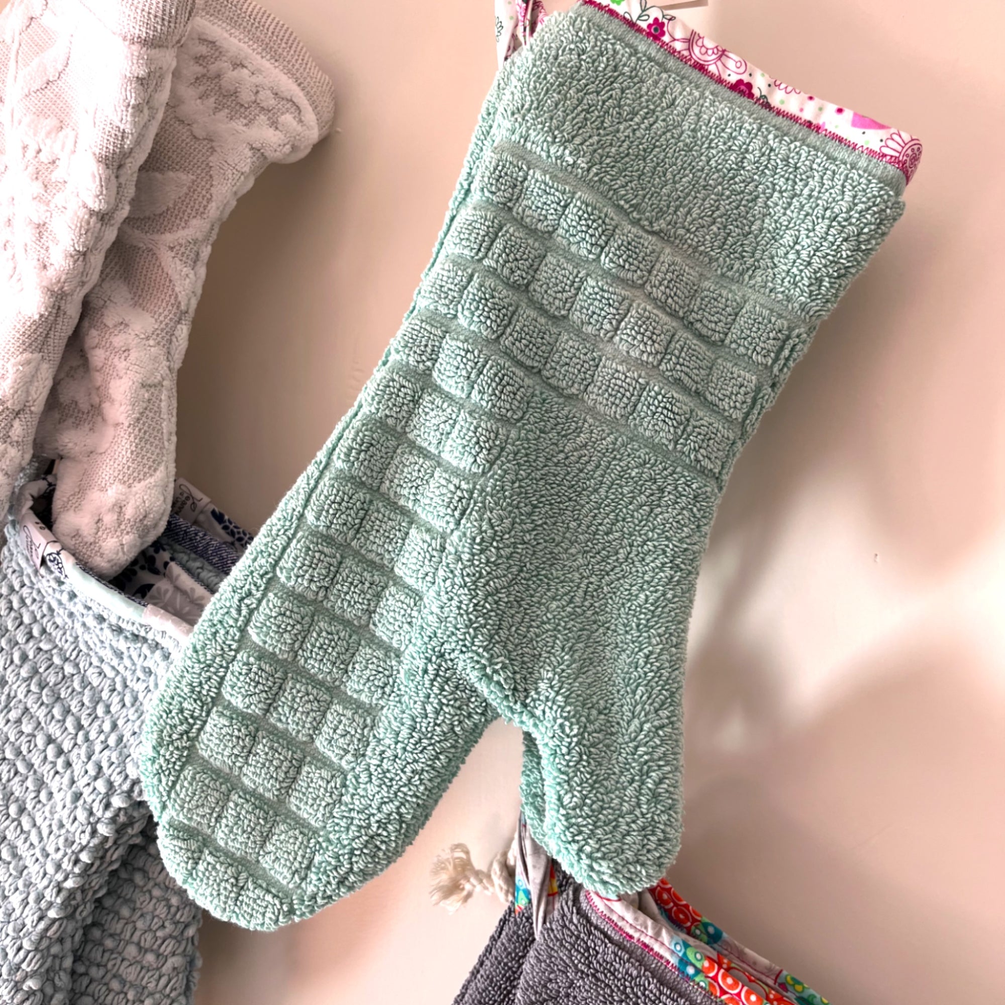 Genähte upcycling Ofenhandschuhe, gross im Bild mintgrüne Handschuhe, hinten im Bild weisse und hellblaue Ofenhandschuhe