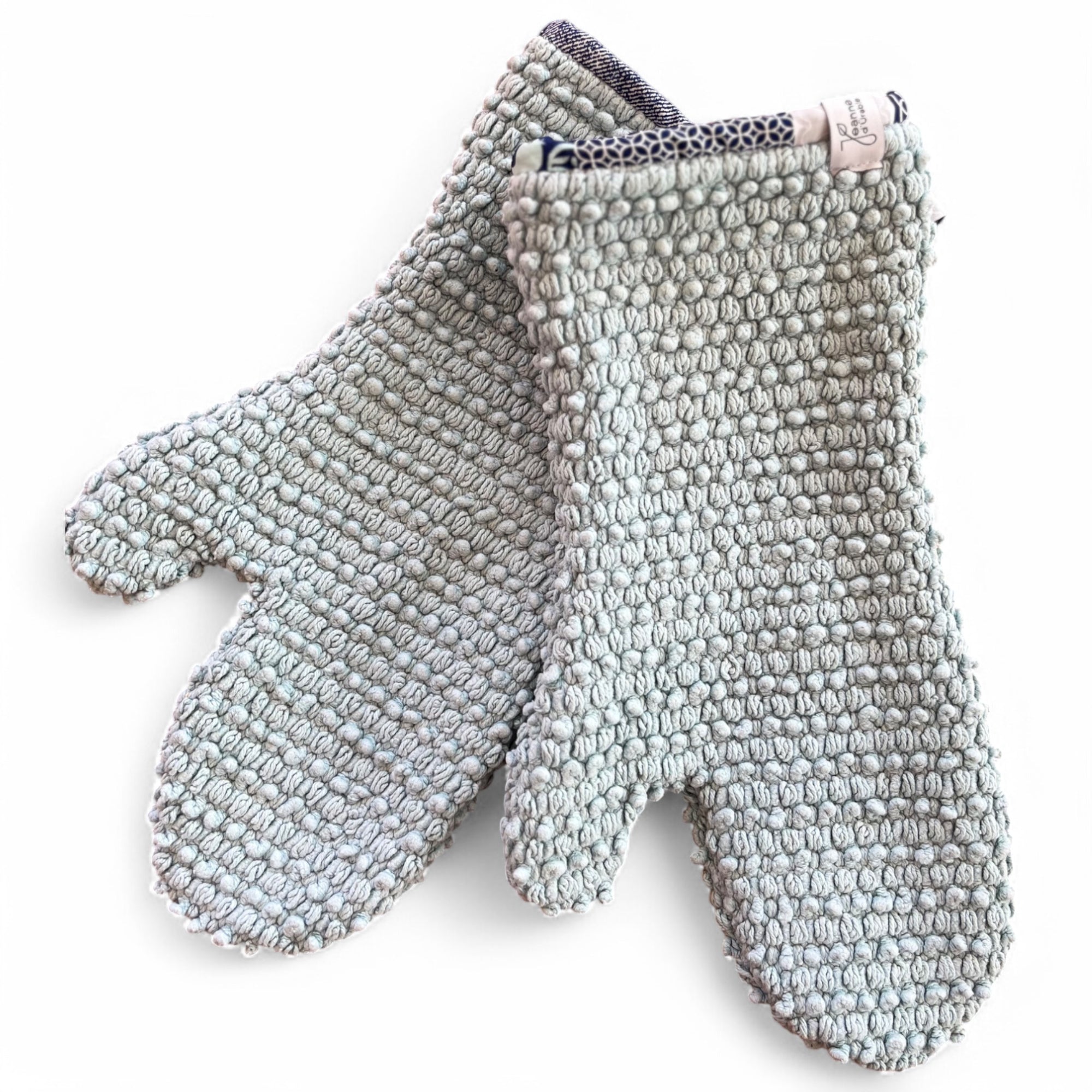 Genähte upcycling Ofenhandschuhe aus einem hellblauen Badezimmerteppich mit blau gemustertem Rand