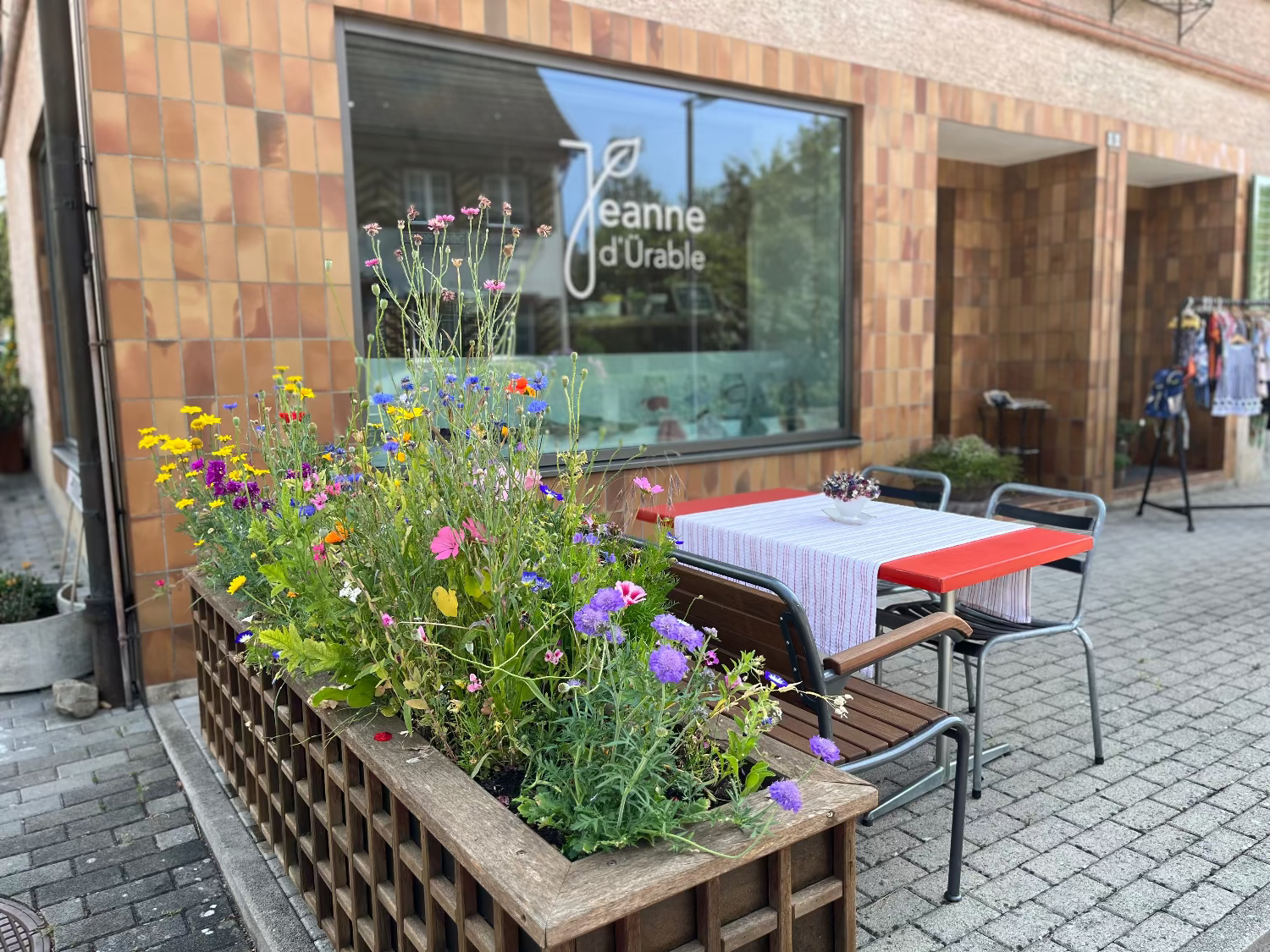 Das bunte Blumenhochbeet vor dem Verkaufsladen von Jeanne d'Ürable