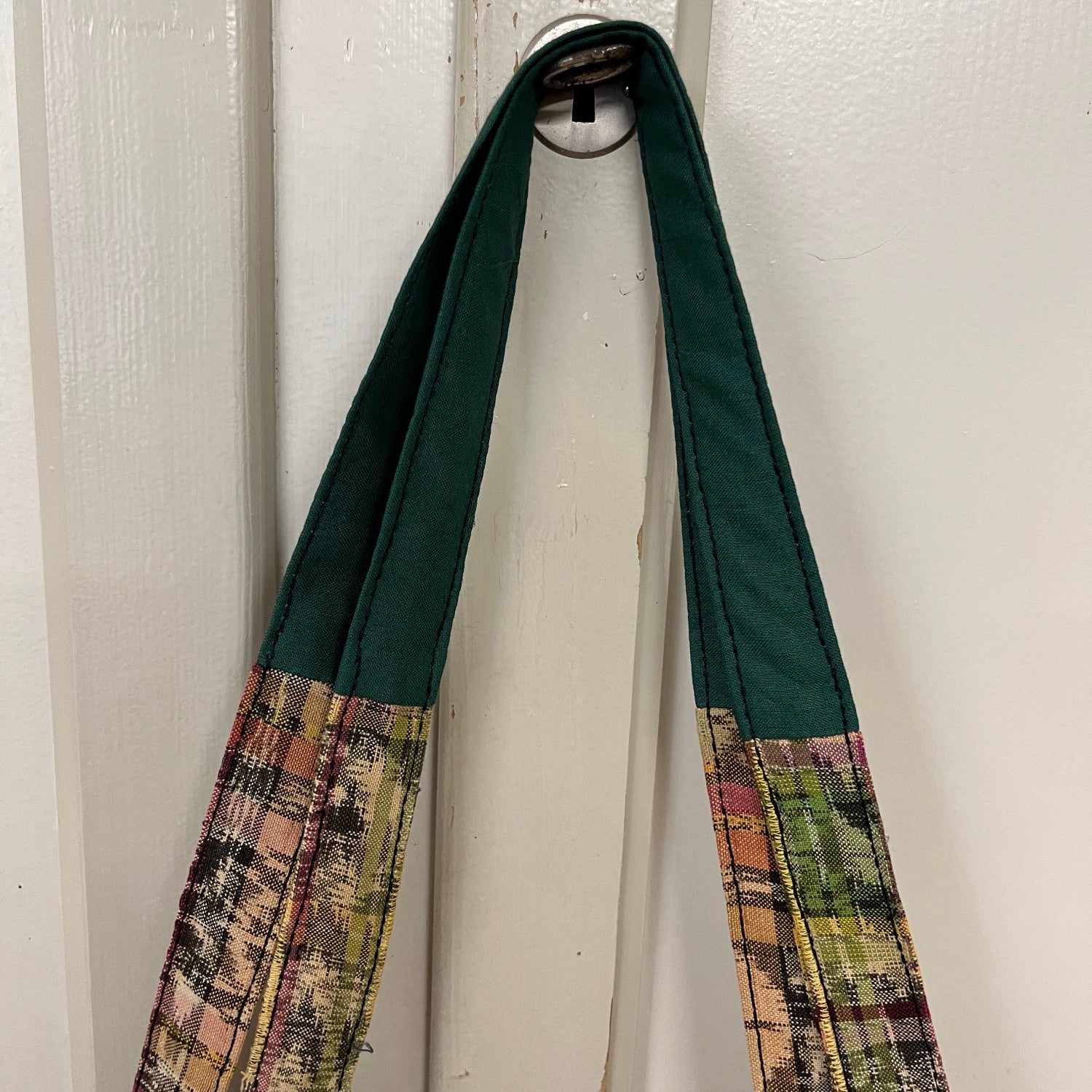 Die Taschenträger sind mit grünem Stoff repariert worden 