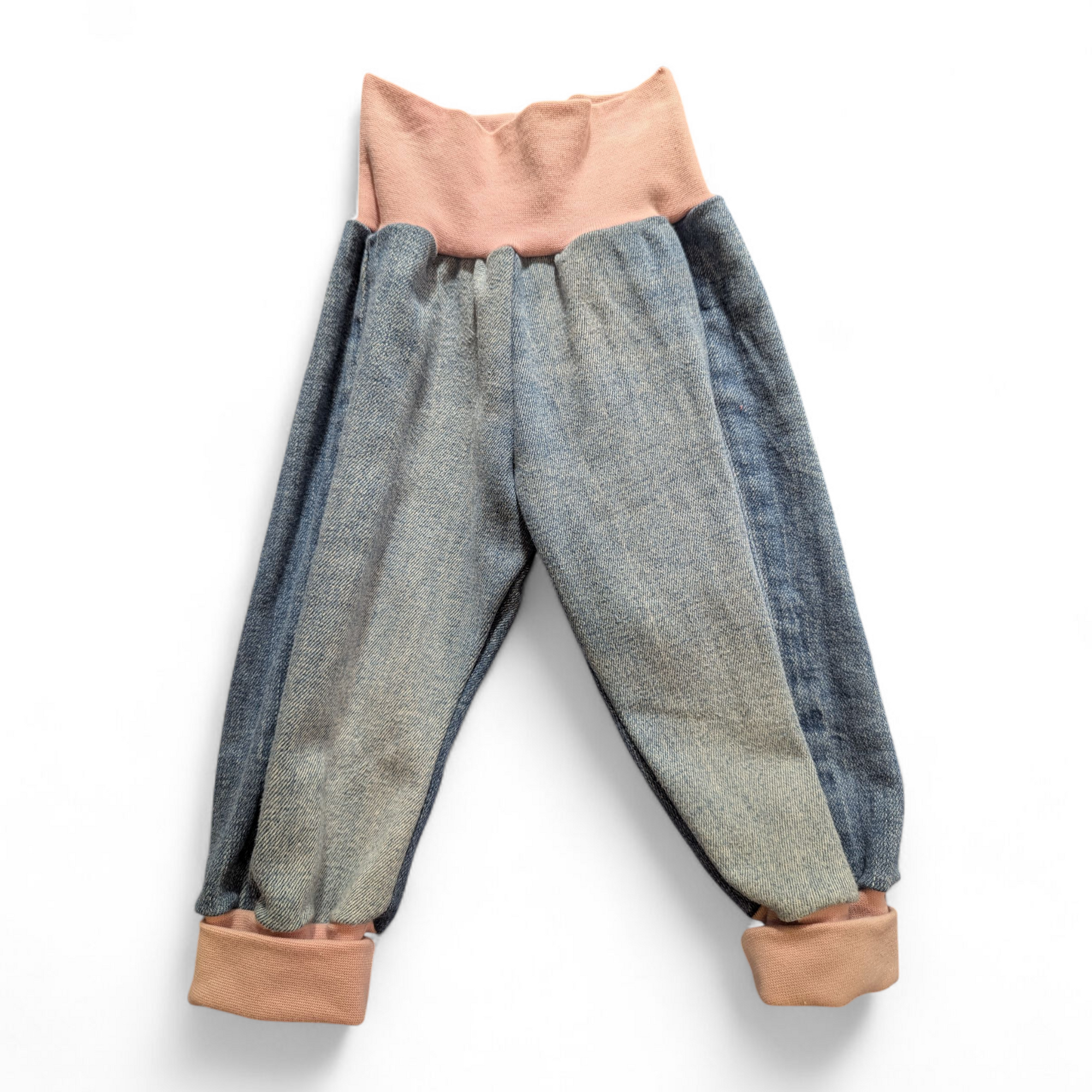 Aus aussortierten Jeans haben wir eine süsse kleine Jeans in der Grösse 68 genäht. Mit rosa Bündchen. 