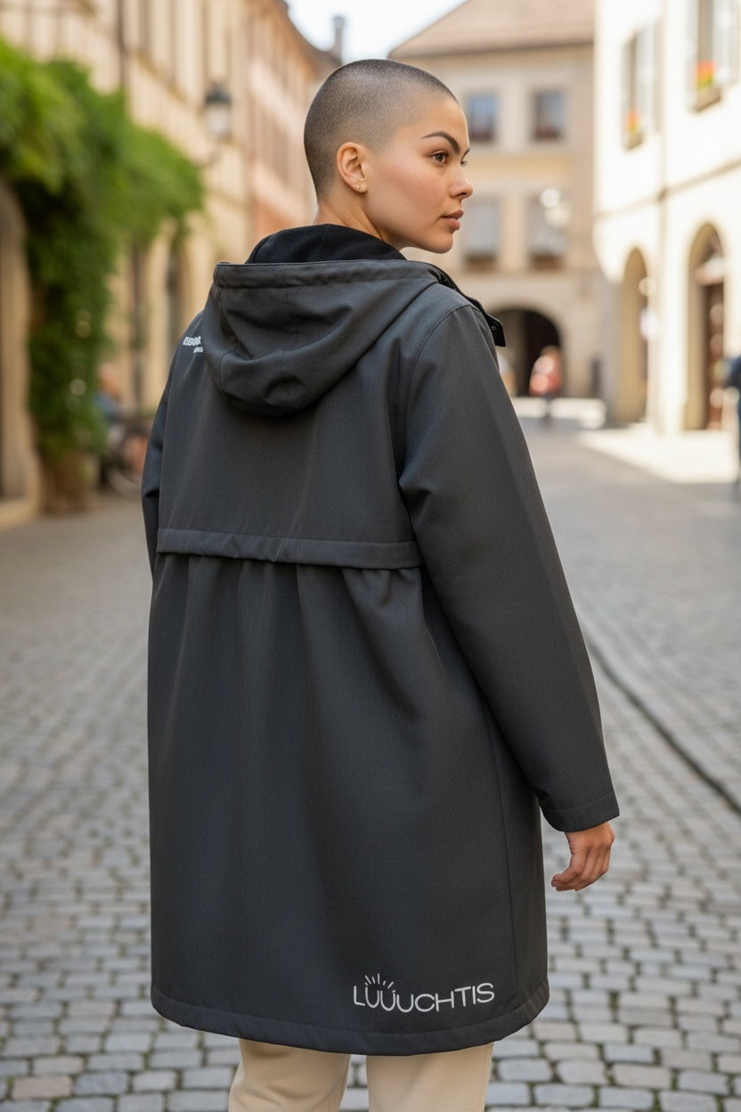 Ein weibliches Model trägt eine schwarze Jacke mit dem Lüüchtis