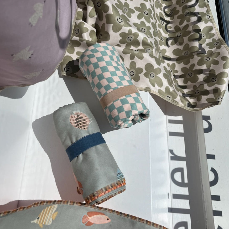 Verschiedene Badetücher aus Mikrofasern  liegen im Schaufenster von Jeanne d'Ürable 
