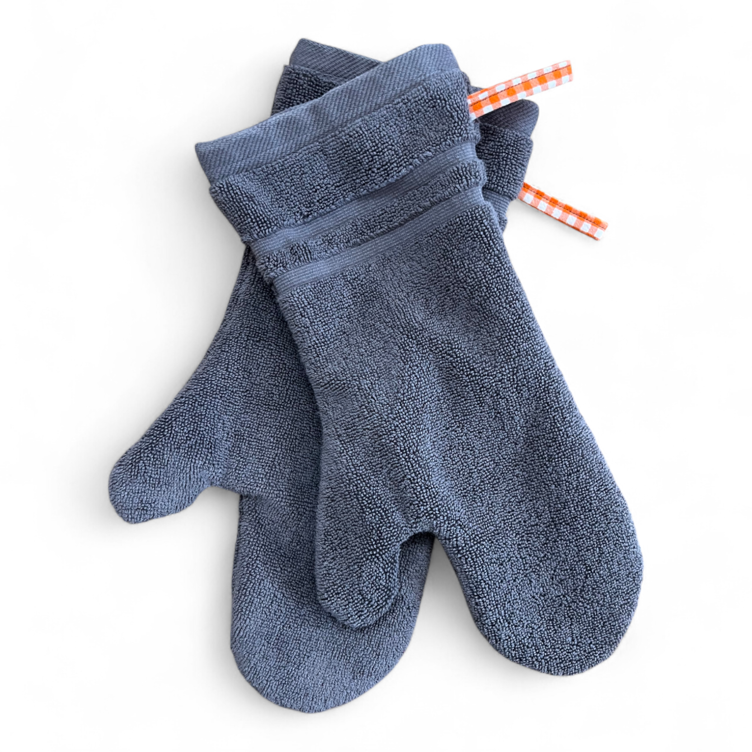 Paar Ofenhandschuhe aus einem umgenähten, dunkelgrauen Badezimmerteppich, gefüttert mit orange-weissem Karostoff