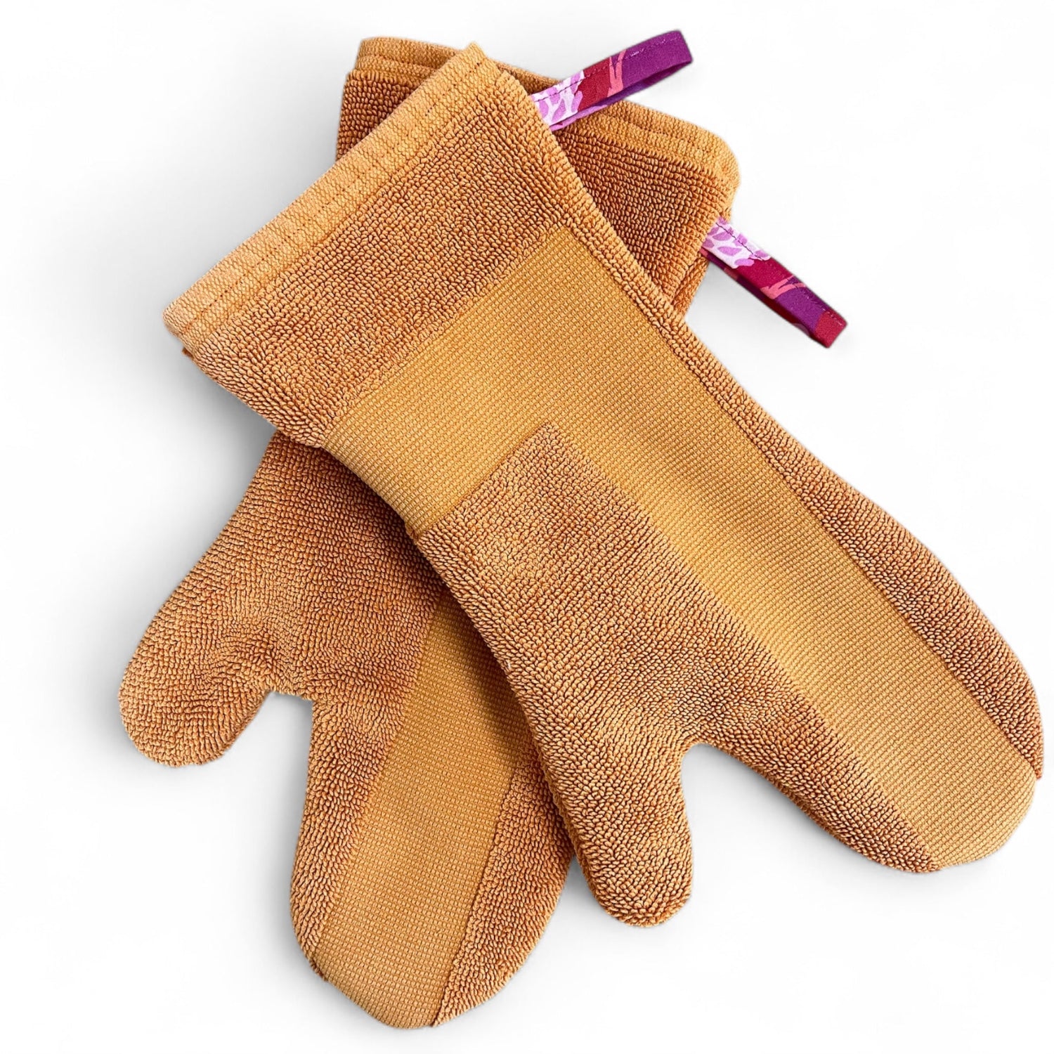 Paar Ofenhandschuhe aus einem umgenähten, orangefarbenen Badezimmerteppich, gefüttert mit pink geblümtem Baumwollstoff