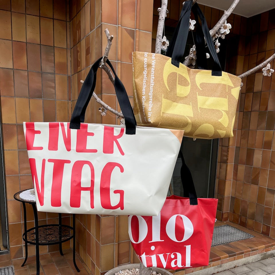 Drei Upcycling-Taschen hängen an einem Ast
