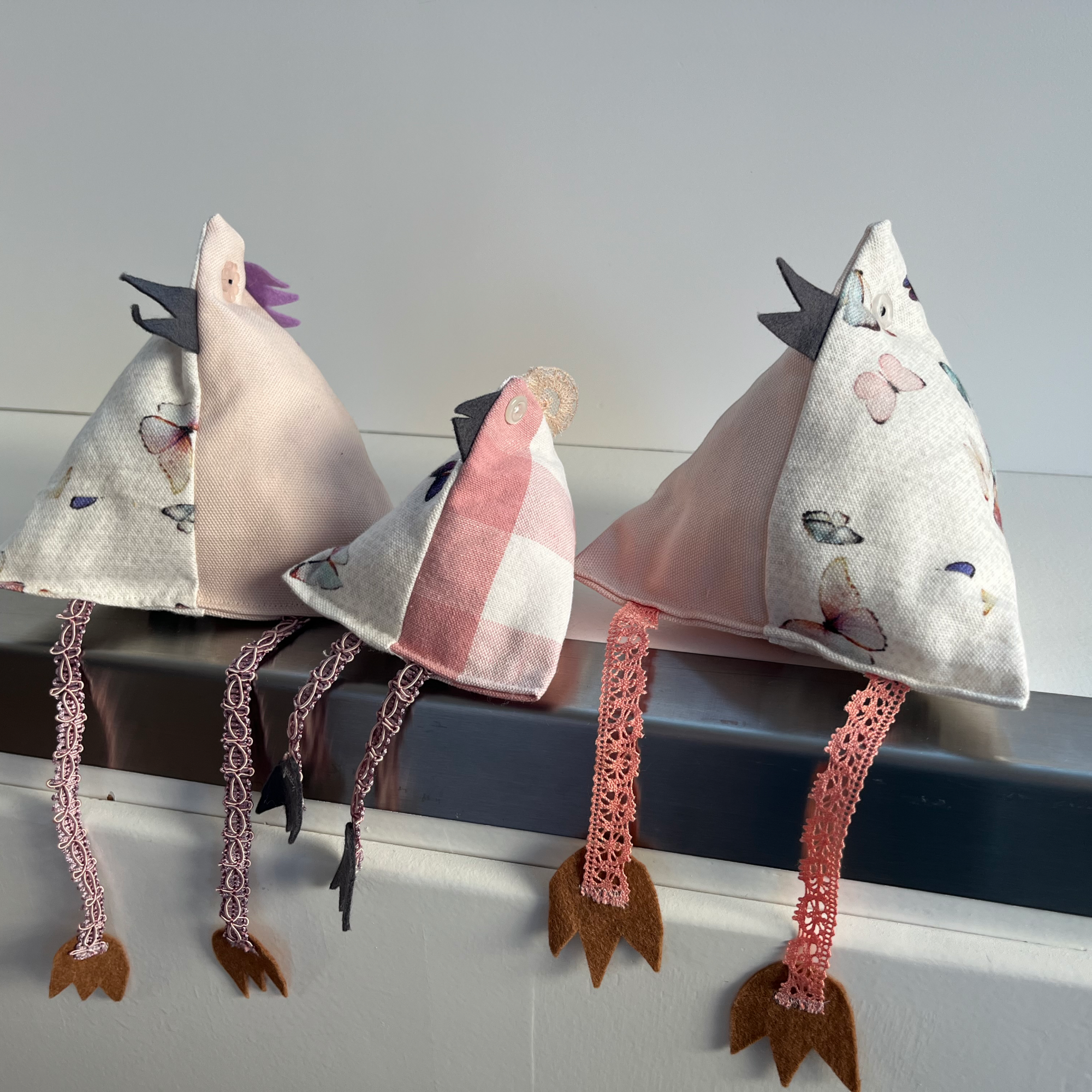 Sitzende Hühner aus Upcycling-Stoffen in verschiedenen Rosa-Tönen