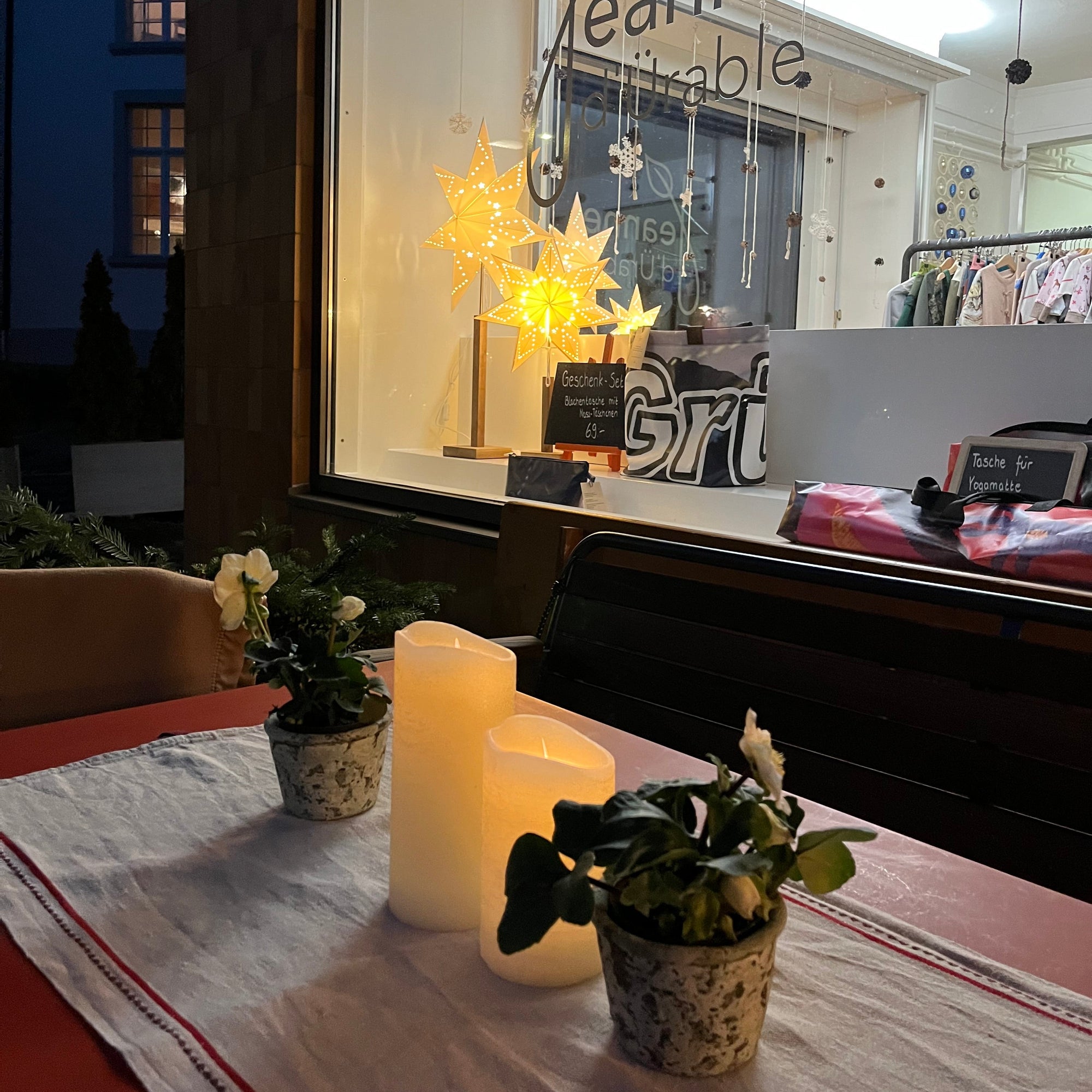 Stimmungsbild mit weihnächtlich geschmücktem Tisch und Schaufenster im Hintergrund