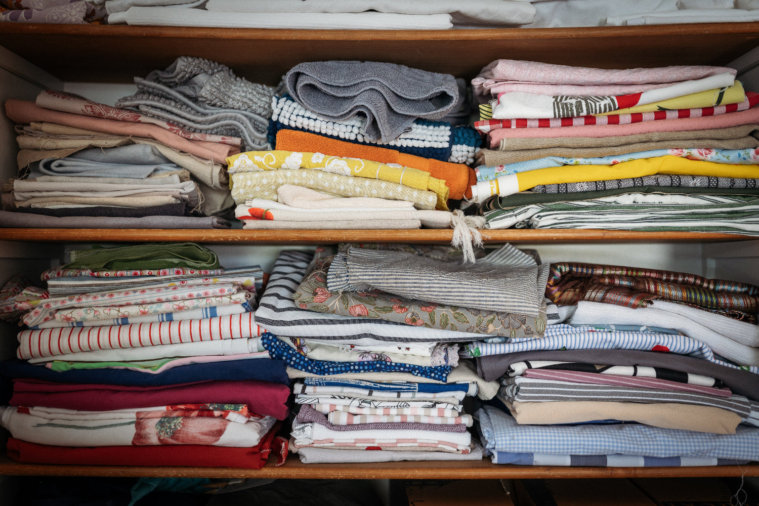 Blick in einen Schrank mit bunt gemischten Textilien