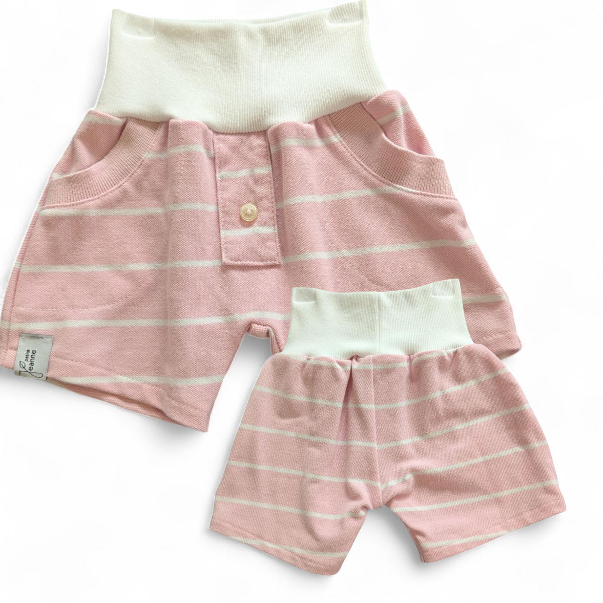 Bunte, kurze Kinderhose aus upgecycelten Stoffen hier aus einem Poloshirt mit elastischem Bund, nachhaltig hergestellt und ideal zum Spielen und Toben. Farbe Rosa-Weiss-gestreift mit weissem Bund