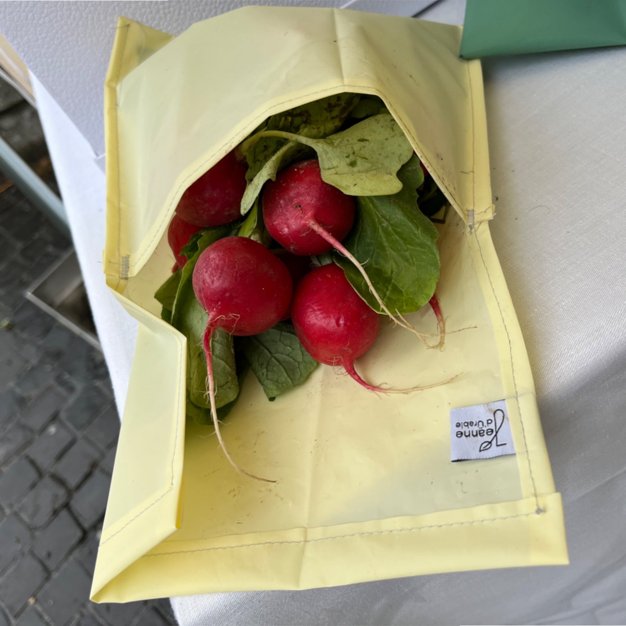 kleiner gelber Zero-Waste-Beutel aus PEVA Material mit Radieschen gefüllt